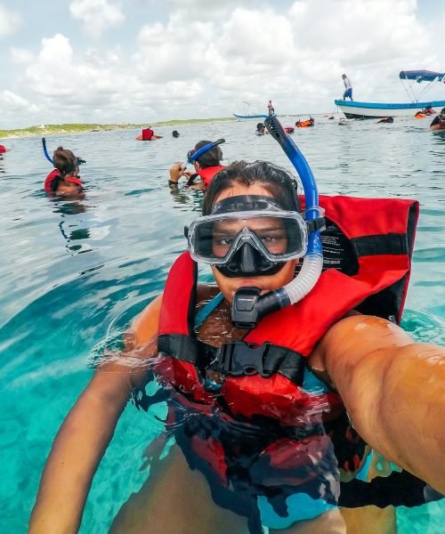 Selfie of woman wearing life jacket snorkelling in ocean in a group, in Mexico