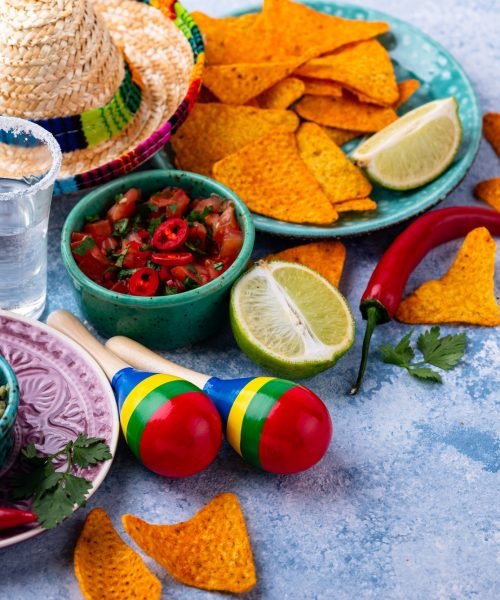 Traditional Mexican food nachos, salsa, guacamole, tequila.